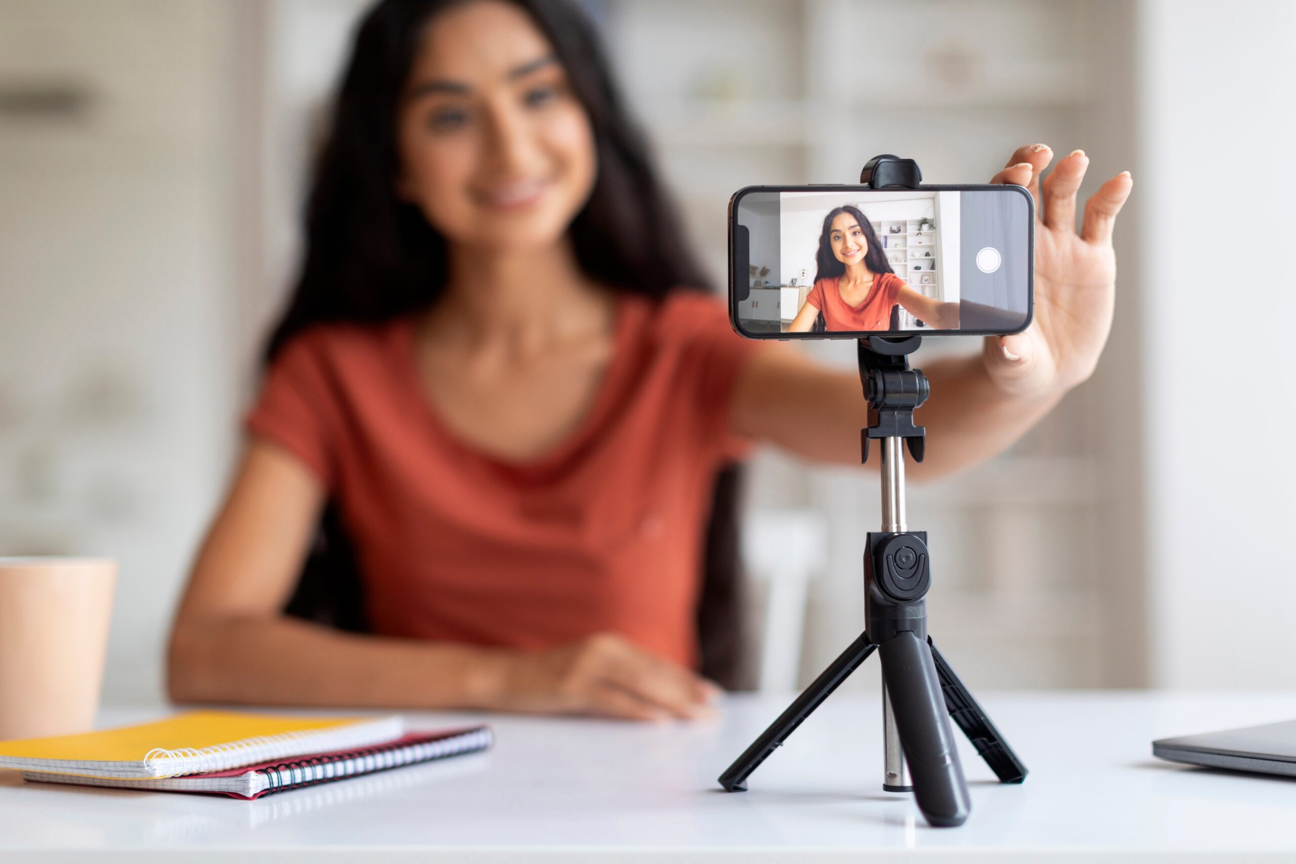 A young actress setting up her landscape phone on a tripod for a self-tape