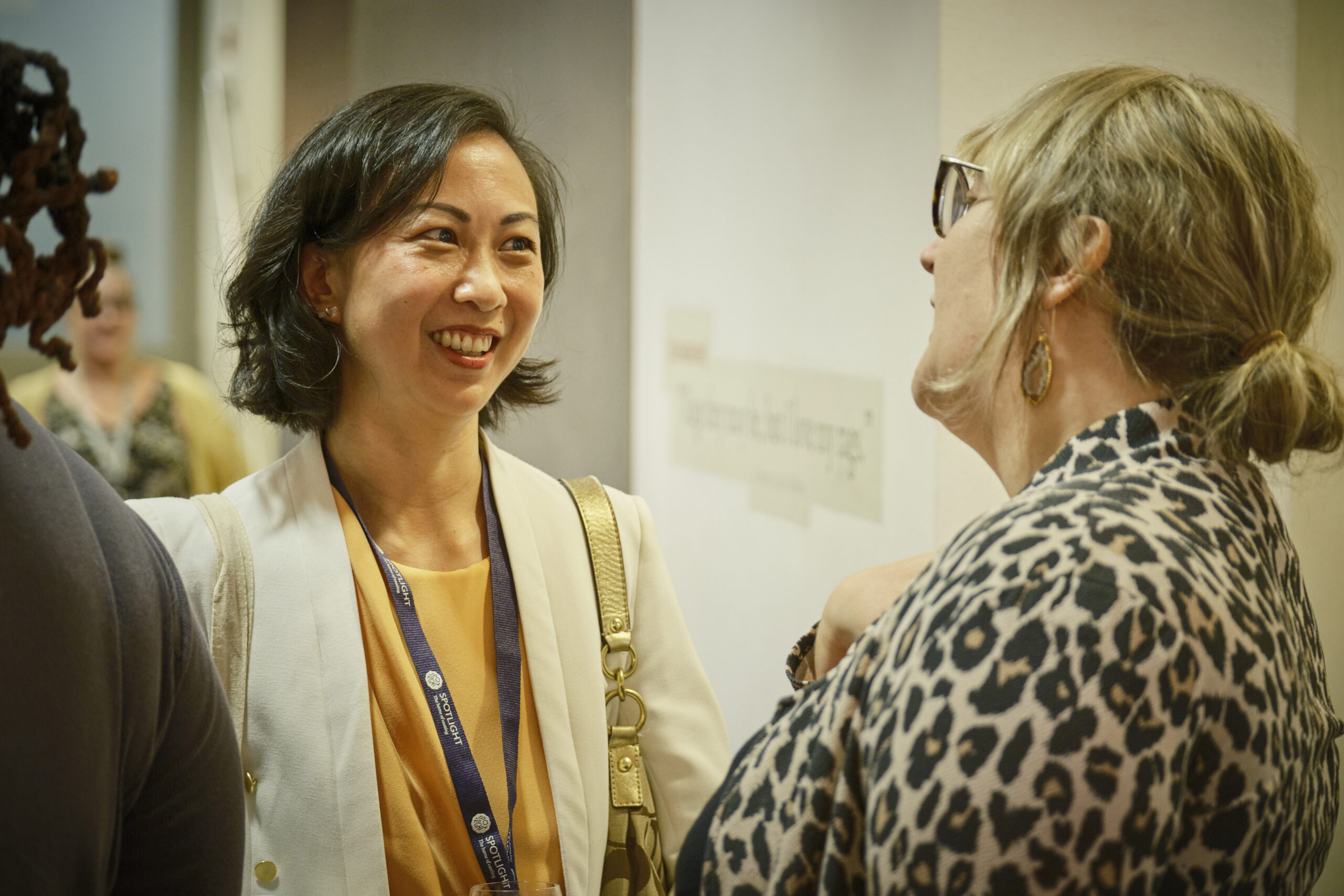 Mel Brown smiling as she talks to agent Mildrea Yuan at a Spotlight Industry Forum event.