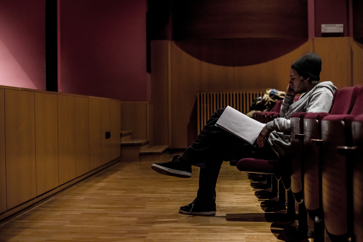 Actor reading a script in an empty theatre