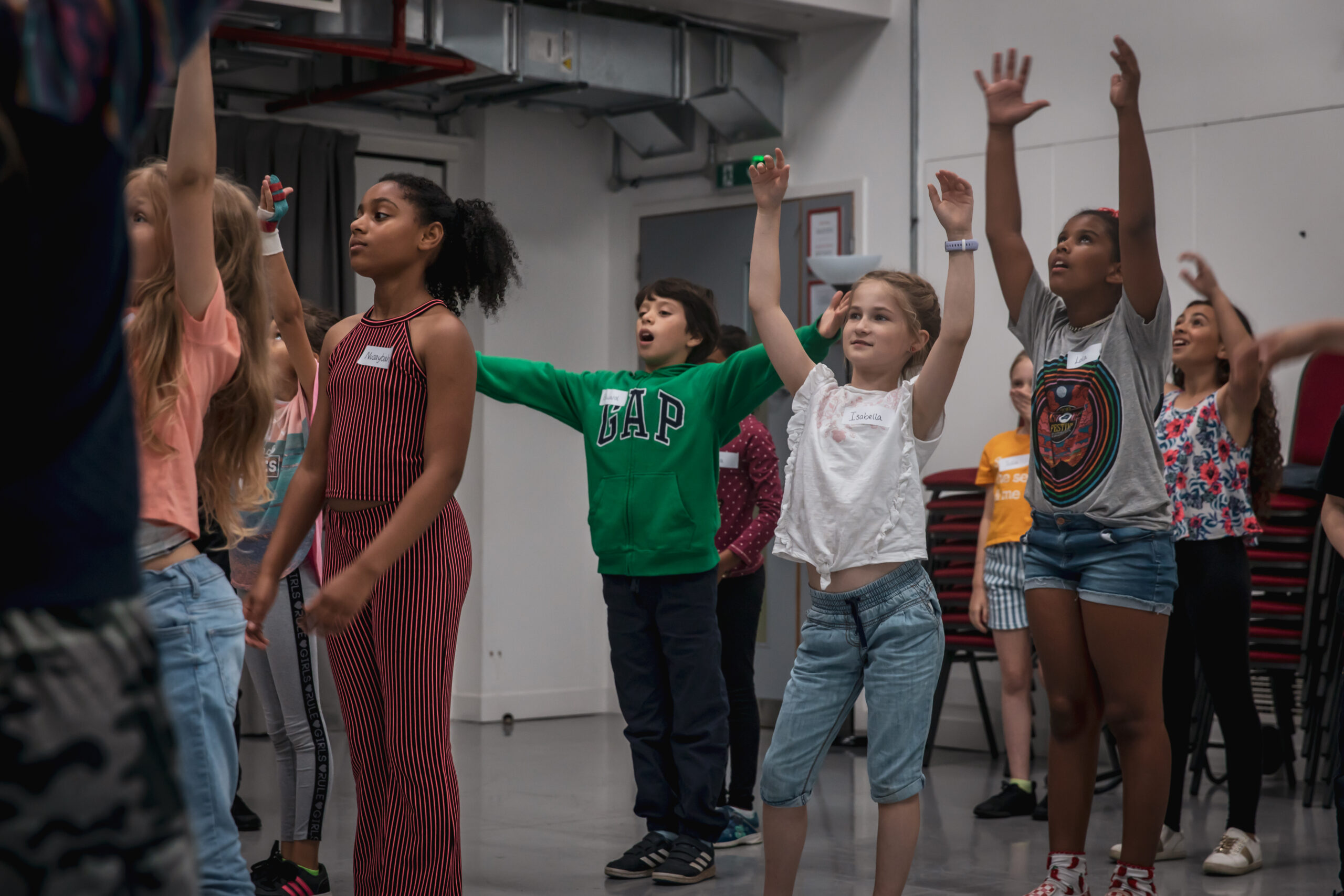Young performers with their hands in the air during a Spotlight workshop