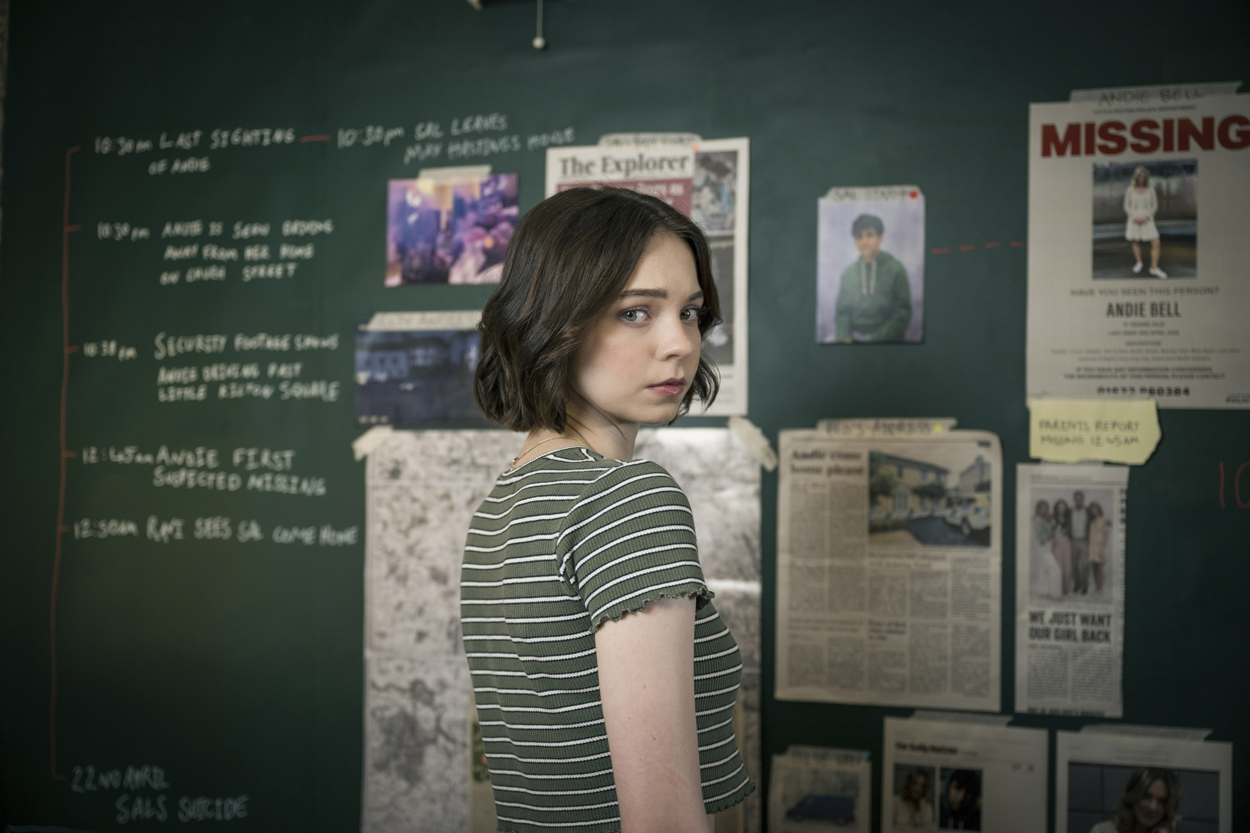 Emma Myers as 'Pippa Fitz-Amobi' looking over her shoulder by her crime mind-map in 'A Good Girl's Guide to Murder'