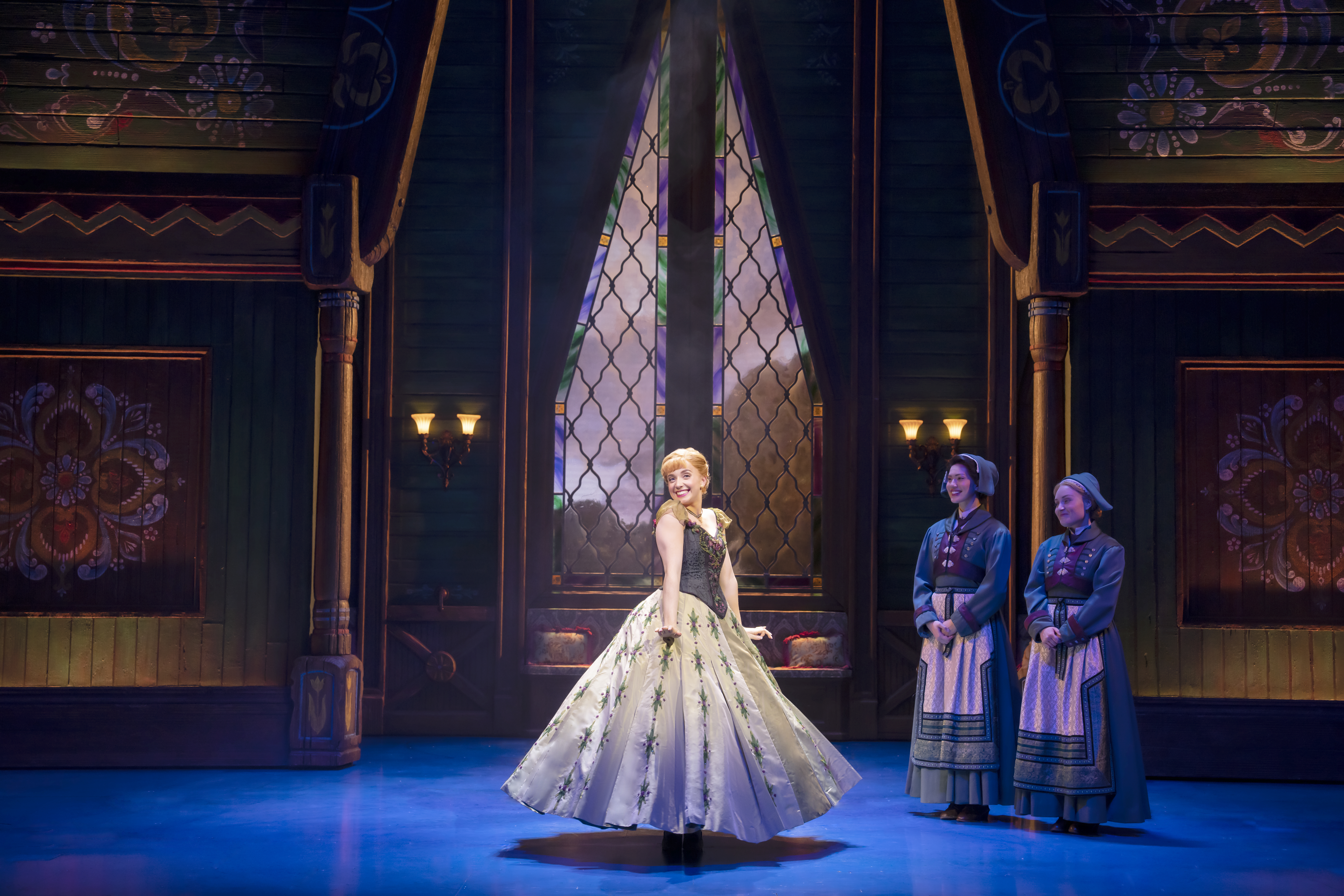 Laura Dawkes in 'Frozen the Musical' as 'Anna' looking happy in her room in her new dress while the two attendants watch