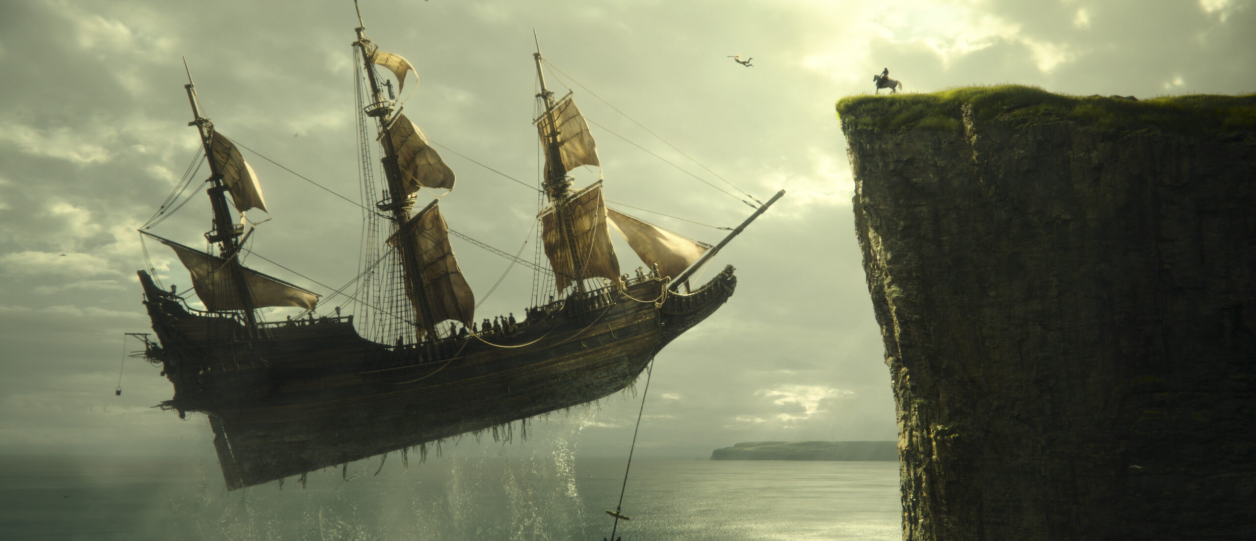 A pirate ship lifting up from the sea while someone jumps onto it from a cliff in 'Peter Pan & Wendy'