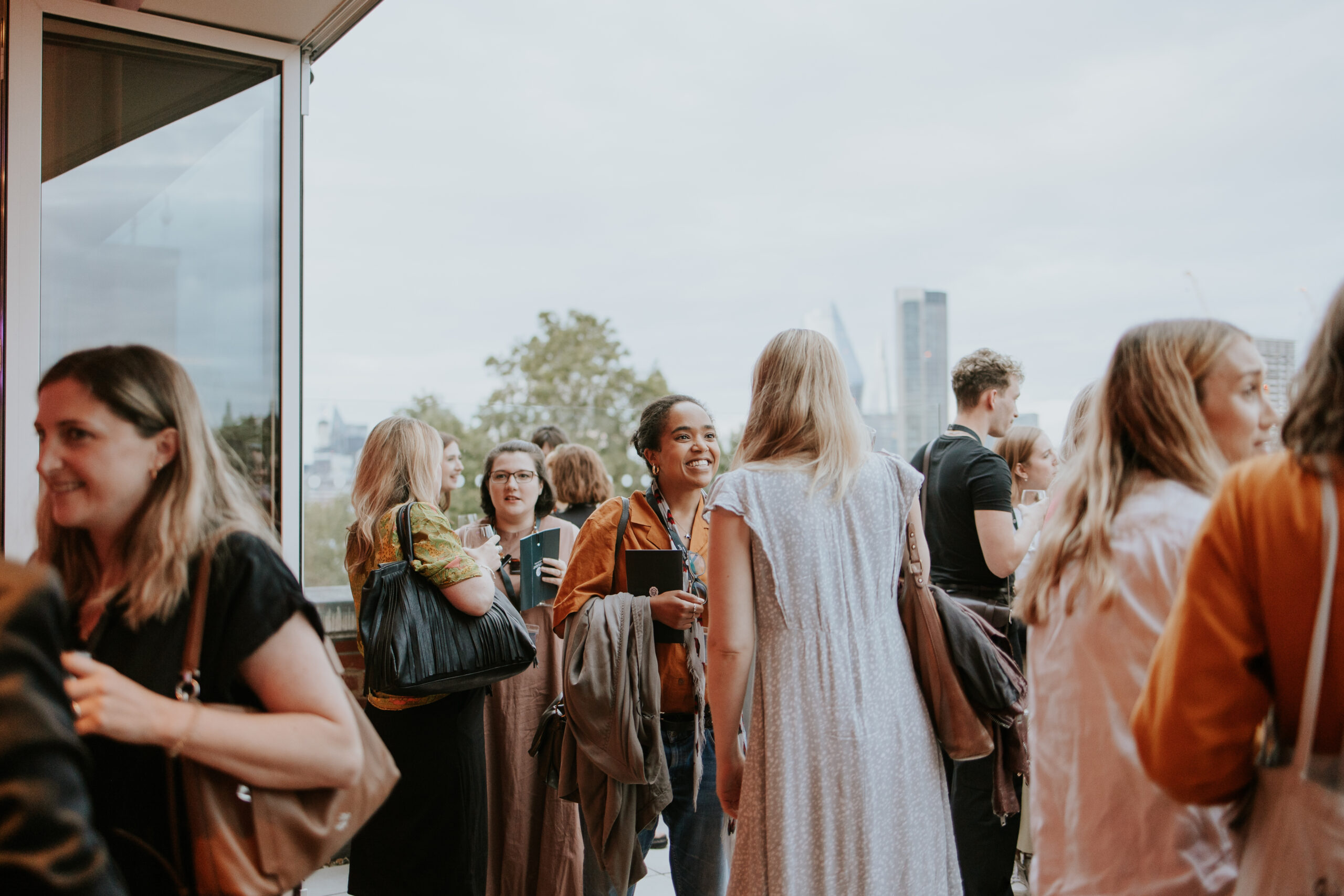 People at a performer showcase, talking and smiling