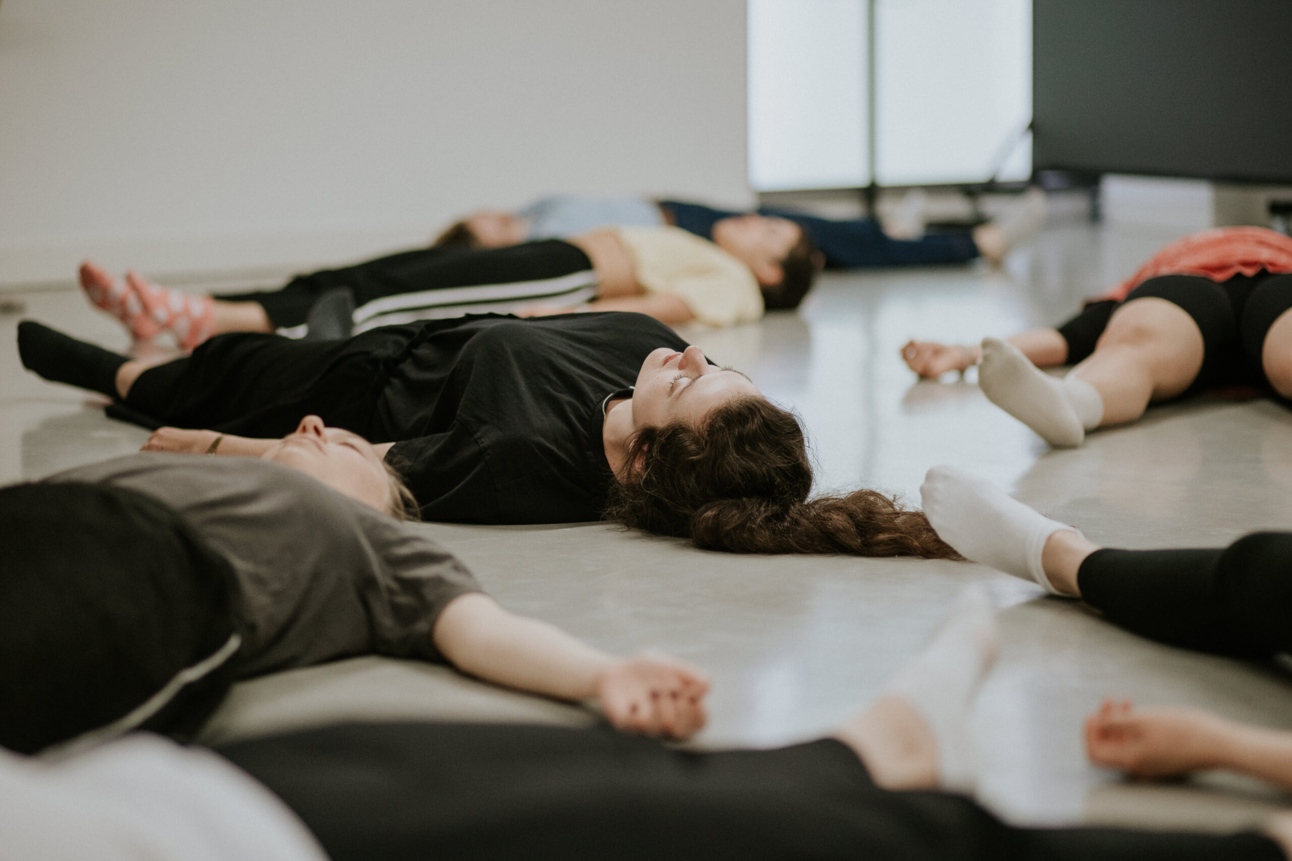 Actors lying on the floor with their eyes closed during a Spotlight workshop