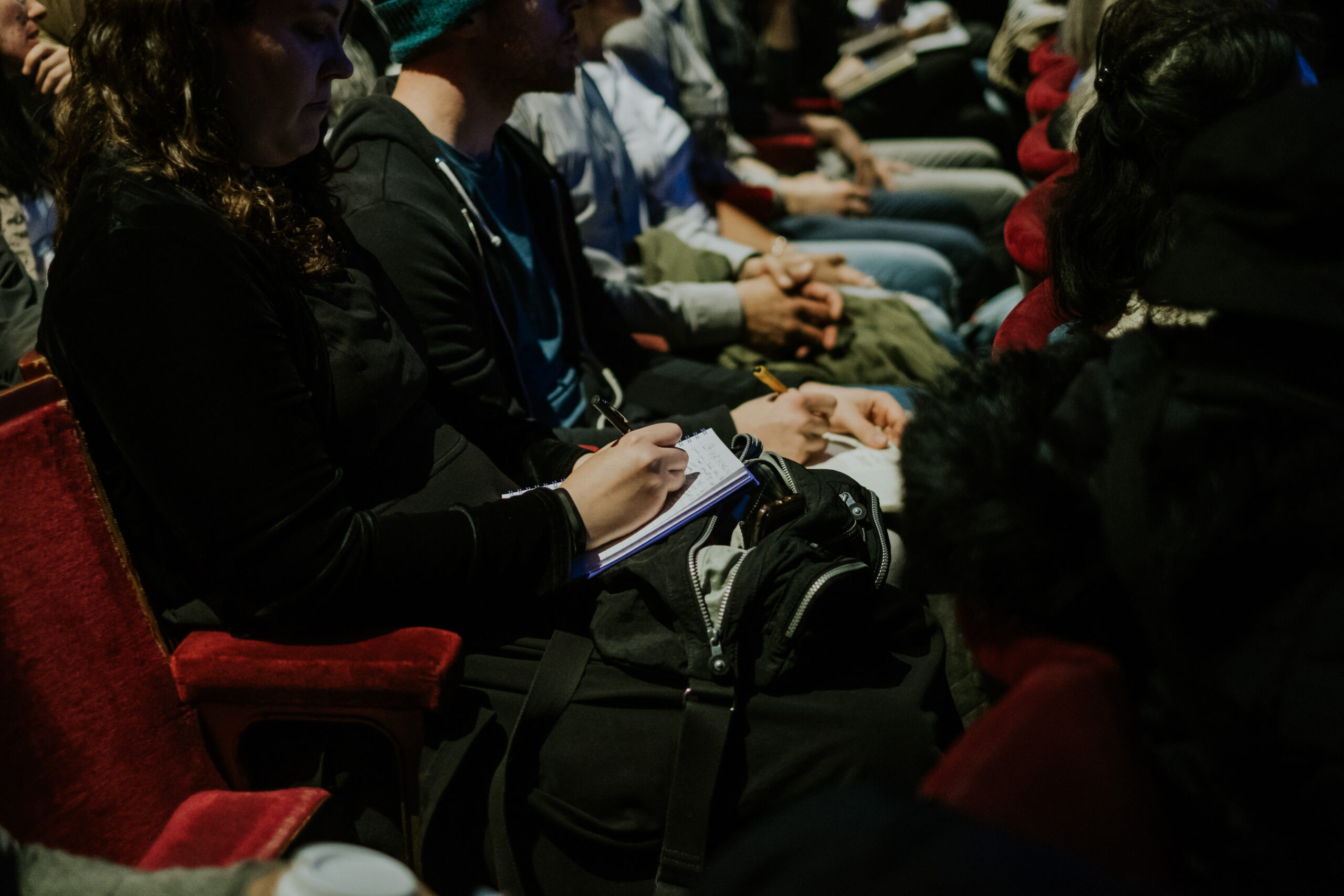 Actors taking notes while sitting in theatre seats