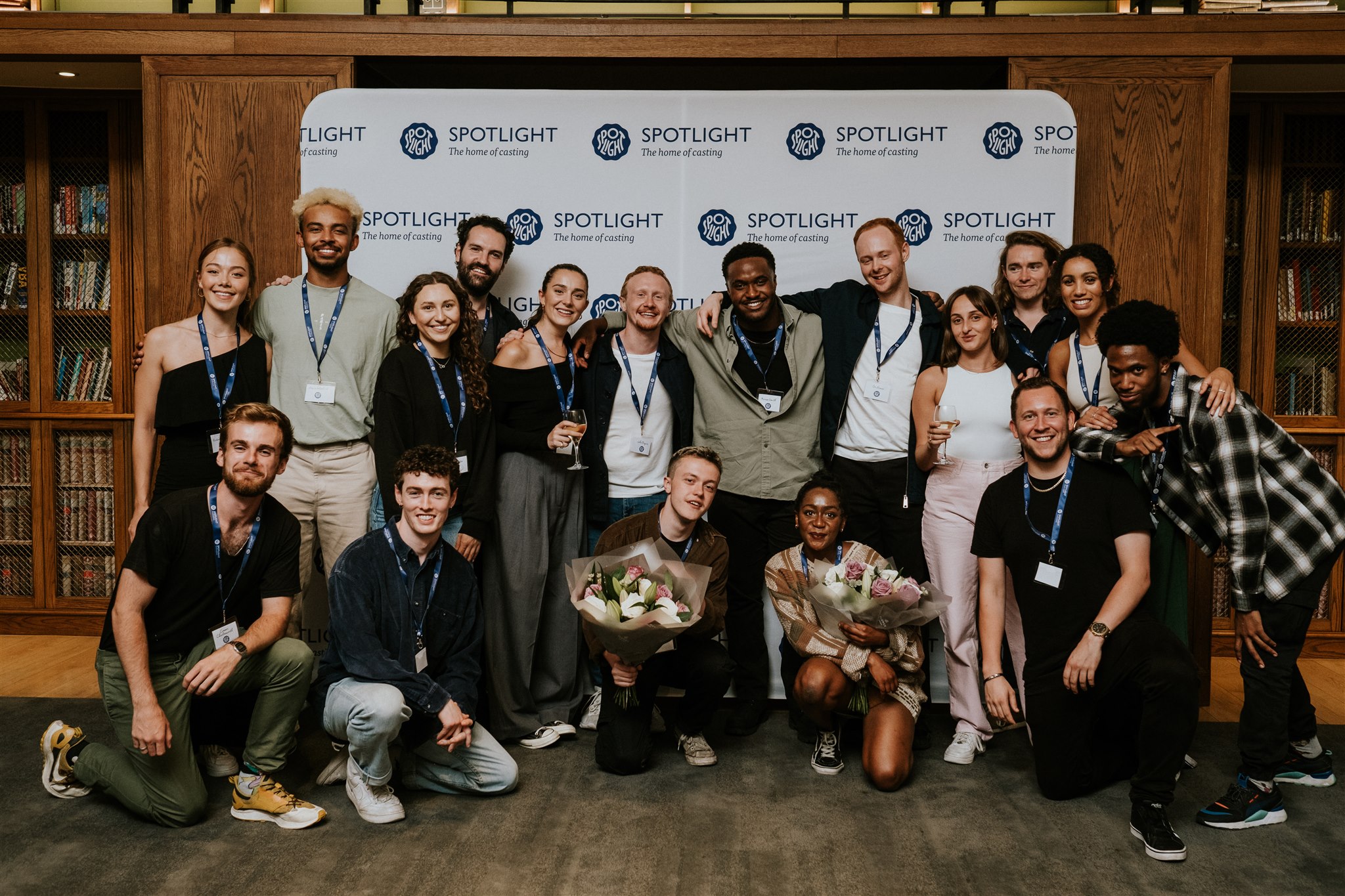 A group of performers in front of a white background.