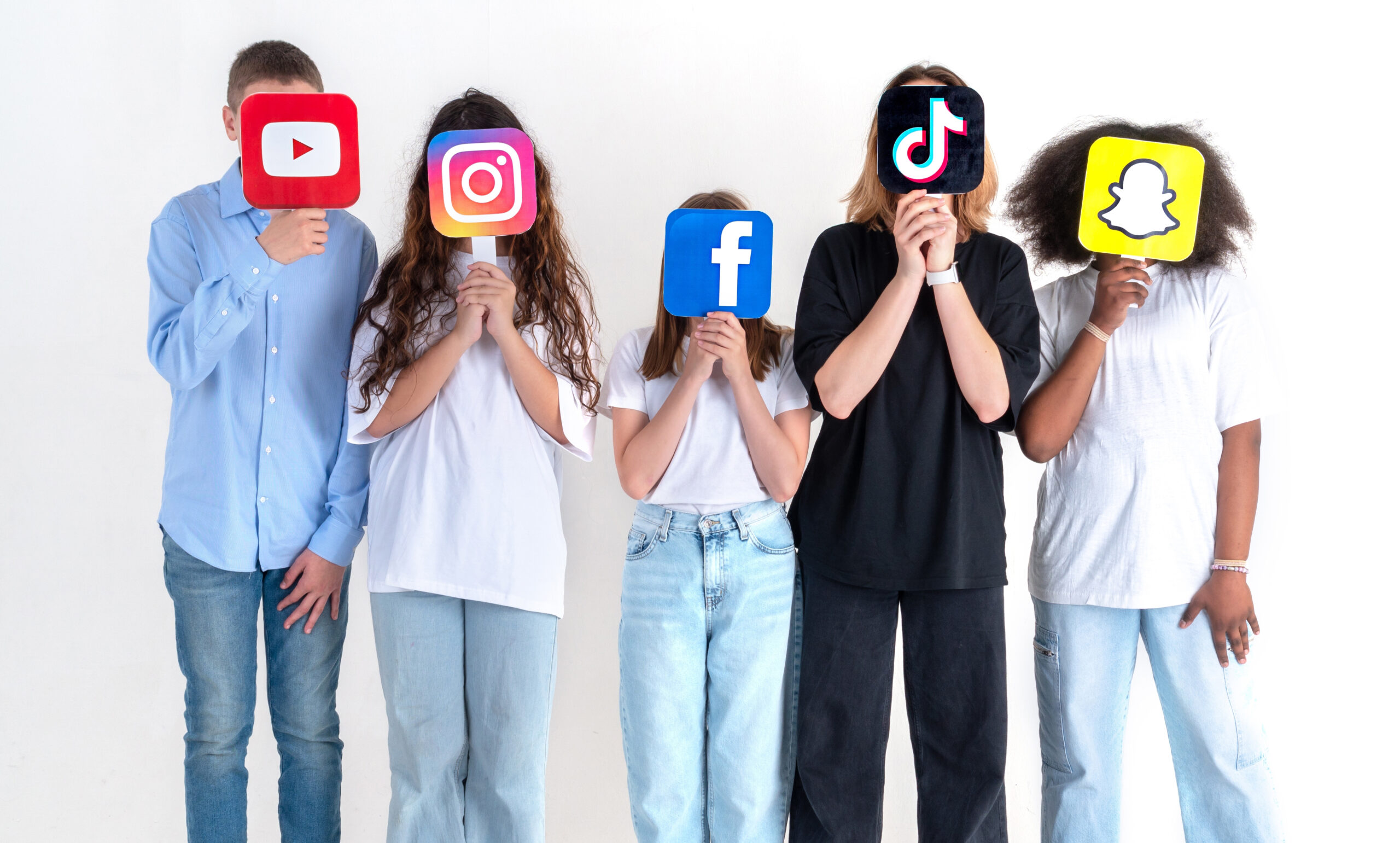 Five children holding a YouTube, Instagram, Facebook, TikTok and Snapchat icon in front of their faces