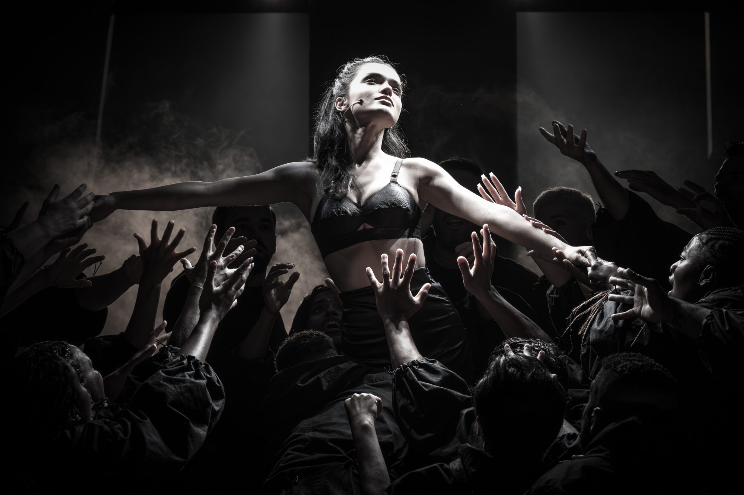 Rachel Zegler being lifted by many hands in 'Evita'