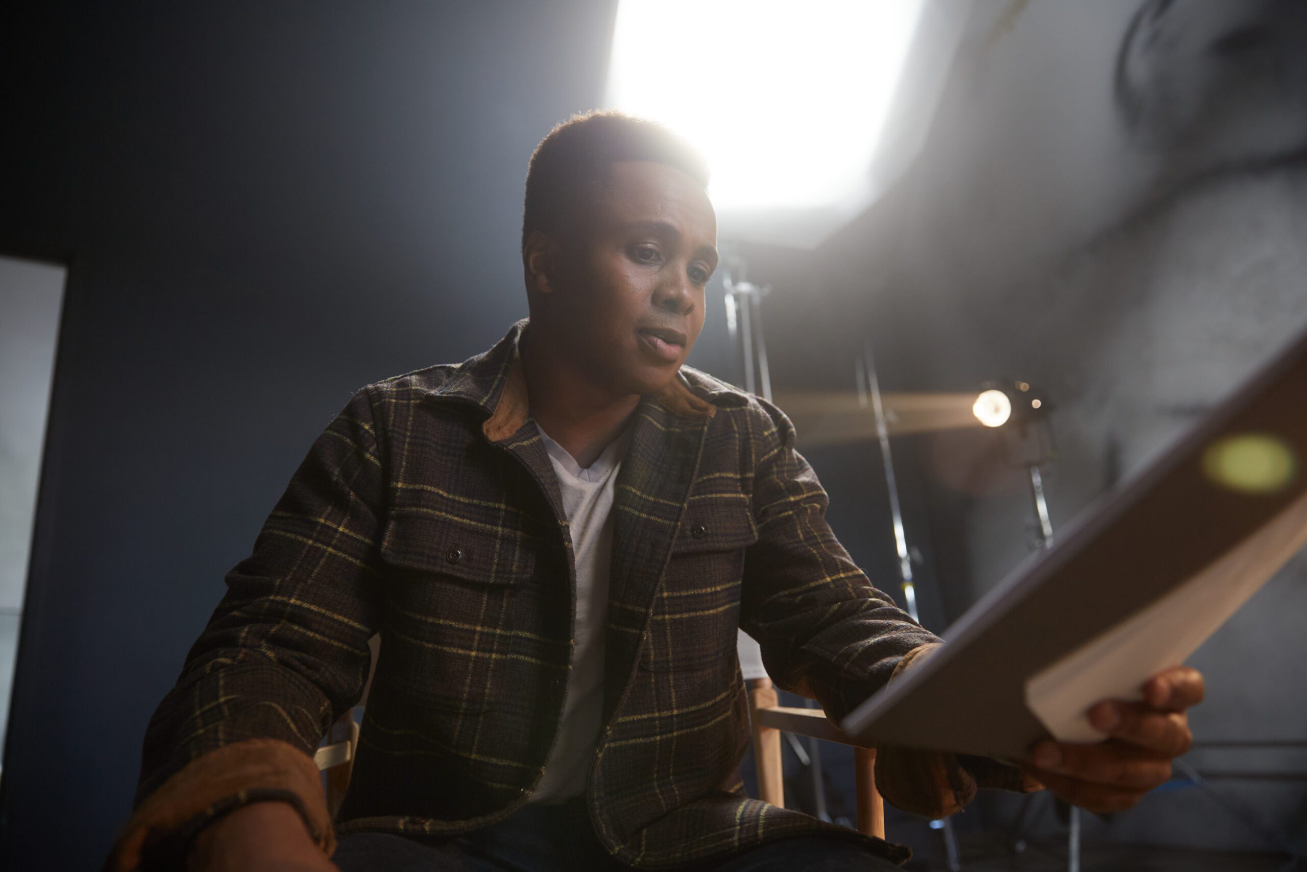 An actor reading a script in a studio
