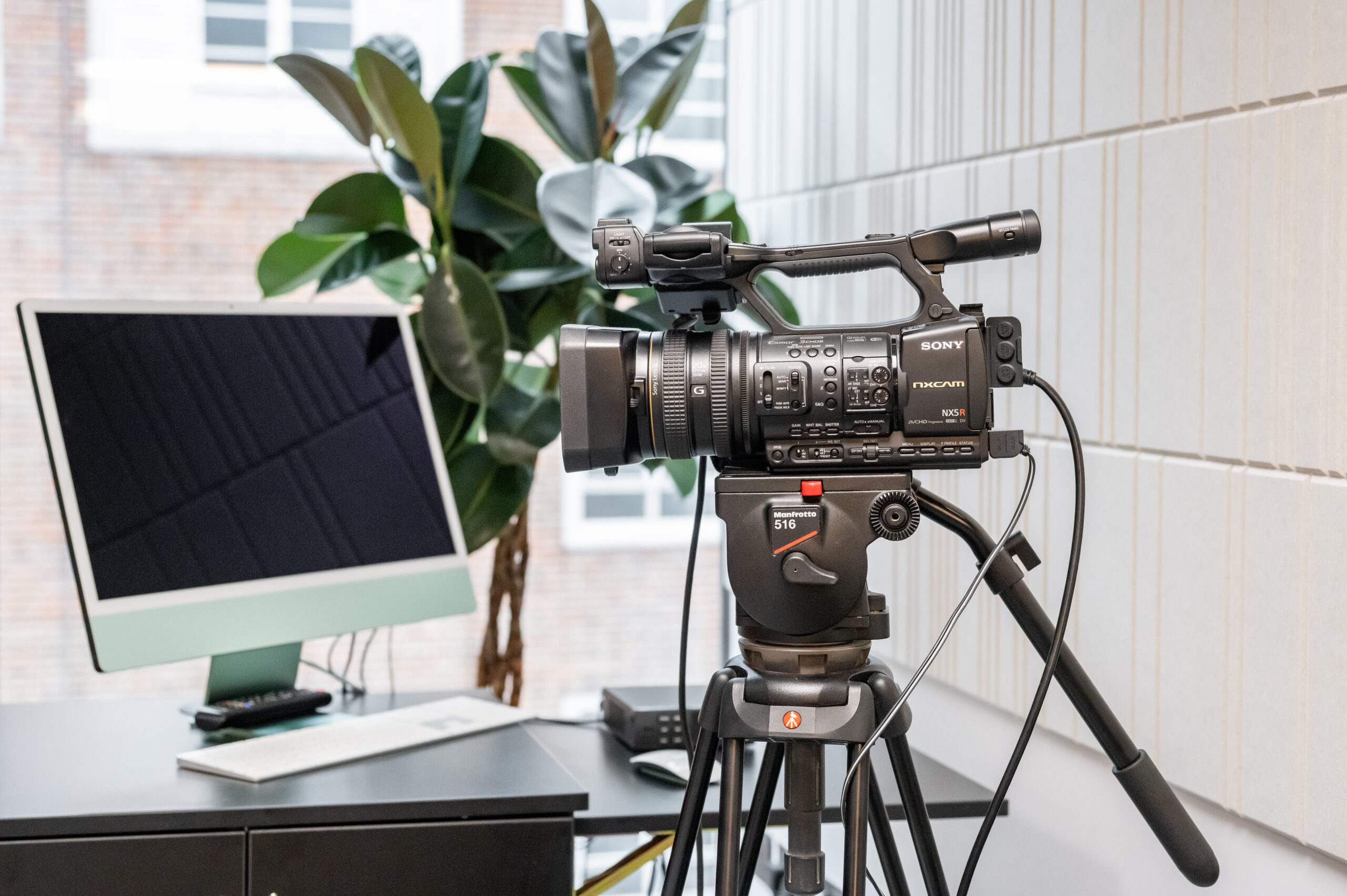 A film camera in a studio next to a Mac